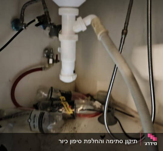 צנרת מתחת לכיור עם חיבורים וצינורות